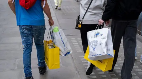 Getty Images Two men carrying shopping bags