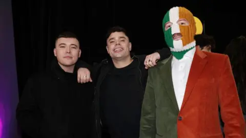 Getty Images Kneecap members Mo Chara, Moglai Bap and DJ Provai standing together.