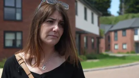 BBC Cat Eccles standing in front of houses