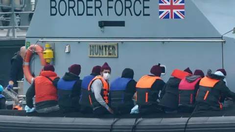 PA Media A group of people thought to be migrants are brought in to Dover, Kent, onboard a Border Force vessel, following a small boat incident in the Channel.