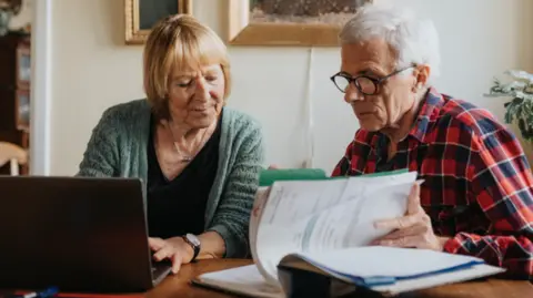 Johner Images/Getty Images Senior couple using laptop at home