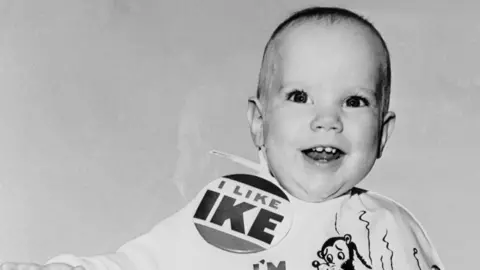 Getty Images Monochrome image of smiling baby wearing an 