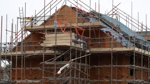 PA Media A new house being built surrounded by scaffolding