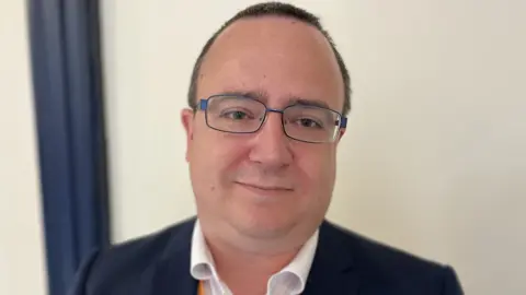 Councillor Daniel Adams, Swindon Borough Council with short brown hair and black rimmed glasses