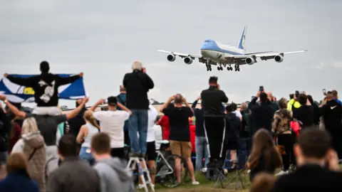 Getty Images A crowd of people watch as the presidential plane Air Force One comes into land at Prestwick Airport