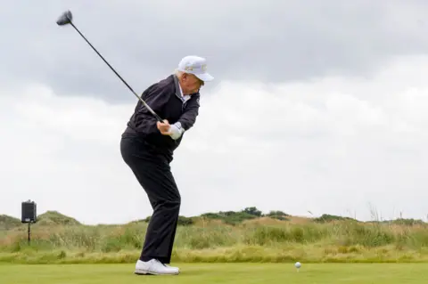 PA Media Guests watch Donald Trump tee off at his new golf course in Aberdeenshire.