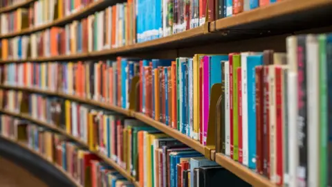 Getty Images Rows of books on shelves. The books are all different colours.