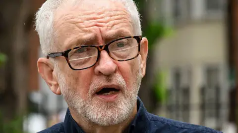 Getty Images Jeremy Corbyn wearing glasses and a blue shirt