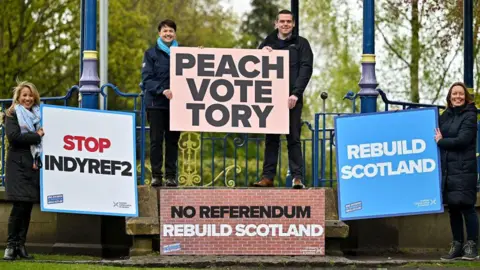 Getty Images Scottish Conservative campaigners ahead of the 2021 election, including then leader Douglas Ross and his predecessor Ruth Davidson. They are holding up a placard reading