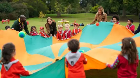 Getty Images A smiling Catherine, Princess of Wales, US First Lady Melania Trump and the Chief Scout Dwayne Fields play with children from the