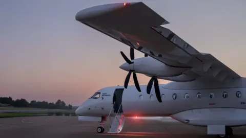 Heart Aerospace Heart's X1 looks like a large private jet. Visible are two propellers on the wing and a ladder leads up to the cabin door.